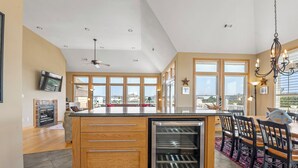 A spacious kitchen with a large island, wooden cabinetry, and a built-in refrigerator. - Sea Spot: Saltwater Pool, Hot Tub, Beach Club Access (Corolla)