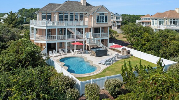 A large two-story house with a swimming pool, outdoor seating, and a covered patio area. - Sea Spot: Saltwater Pool, Hot Tub, Beach Club Access (Corolla)