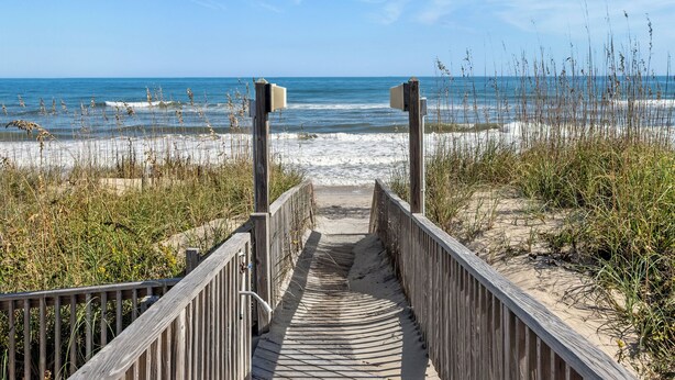 A wooden boardwalk leading to a beach with a clear view of the ocean. - Chirality: Oceanfront | Direct Beach Access (Duck)
