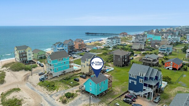 A coastal residential area with houses near the beach and a pier. - It's A Shore Thing: Ocean Views | Hot Tub | Dogs OK (Rodanthe)
