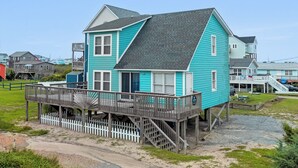 A two-story house with a balcony and a wooden deck. - It's A Shore Thing: Ocean Views | Hot Tub | Dogs OK (Rodanthe)