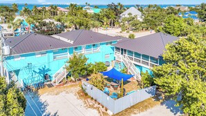 A residential area with a blue building, a staircase, and a view of the ocean. - Seahorse Suites #3. Island Living at it's Best! (Sanibel)