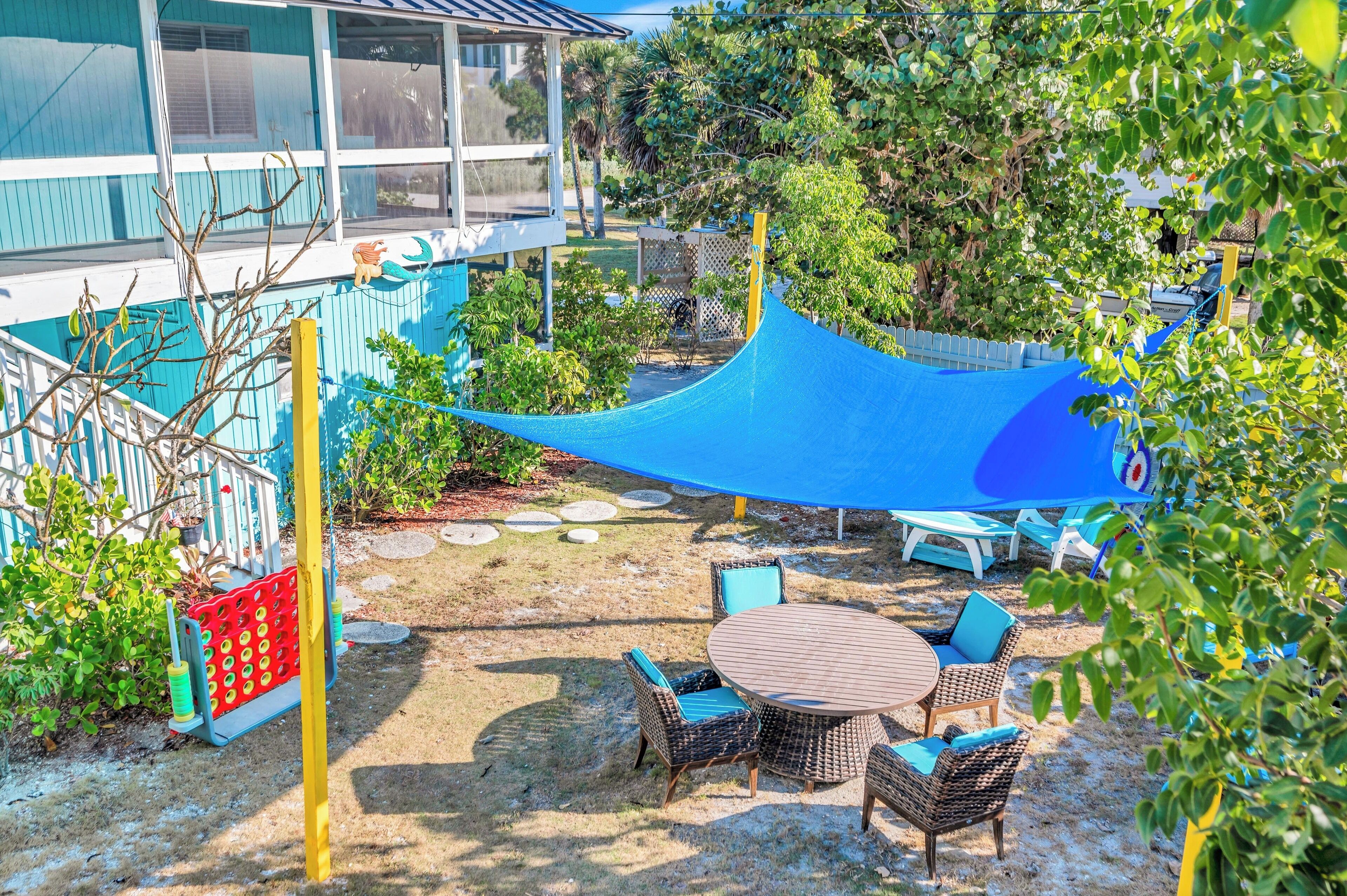An outdoor seating area with wicker furniture and a blue canopy.