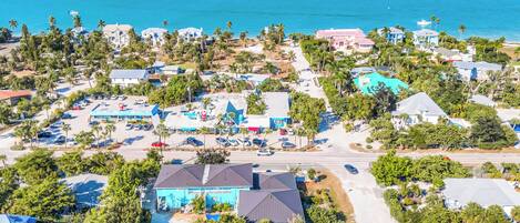 Vista aérea de una zona residencial costera con casas, un puerto deportivo y una playa.
