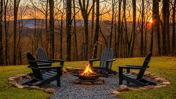 En campingplads med bålsted, fire Adirondack-stole og en grussti.