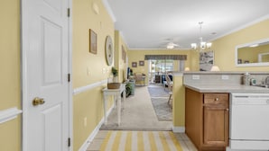 A kitchen with a white stove, a wooden cabinet, and a countertop with a sink. - Barefoot Landing 2BR/2BA at Willow Bend 822. Water View with Pool (North Myrtle Beach)