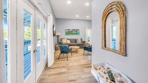A modern living room with a sofa, chairs, and a decorative mirror. - Seahorse Suites #4. A Perfect Beach Getaway! (Sanibel)
