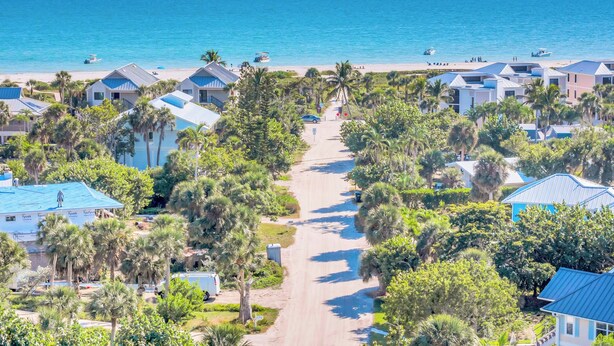 A coastal resort with multiple bungalow-style buildings, a central road, and a beach in the background. - Seahorse Suites #4. A Perfect Beach Getaway! (Sanibel)