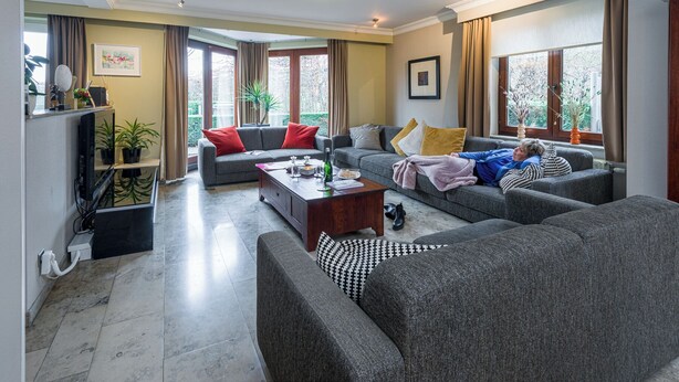 A modern living room with grey sofas, a wooden coffee table, and large windows with curtains. - Comfortable house for 12 p in rustival neighborhoud (BORGLOON)