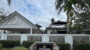 A sign for Sahaswara Luxury Villas with a modern architectural design, featuring a stone facade and a landscaped garden. - Sahaswara Luxury Villa Pattaya (Bang Lamung)