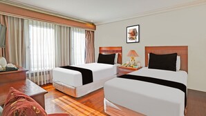 A hotel room with two beds, a desk, a chair, and a window with curtains. - Townhouse Oak VIP Suites, Evangelista Makati Manila (Makati)