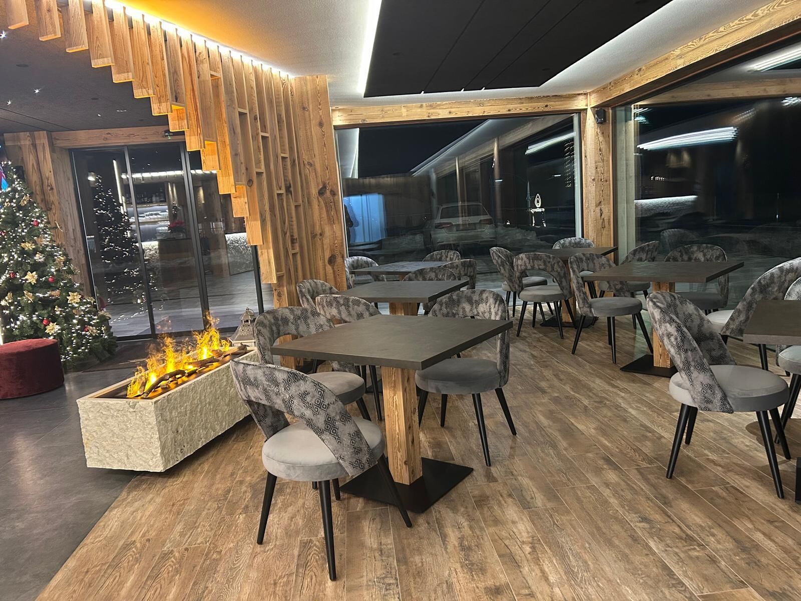 Un restaurante con detalles de madera, una chimenea y un árbol de Navidad.