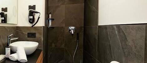 Un baño moderno con un lavamanos grande, una ducha y un espejo.