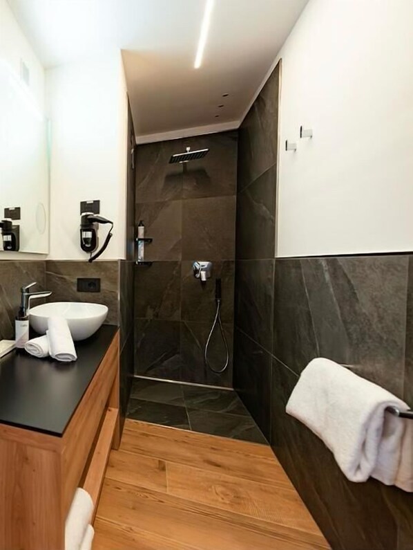 A modern bathroom with a large sink, a shower, and a mirror. - Dolomites Resort  Formiè (San Giovanni di Fassa)