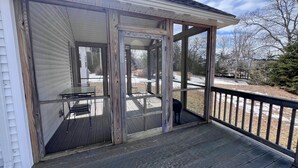 A covered deck with a glass door leading to an outdoor patio area. - Welcome to Owl House - Your Coastal Retreat in East Boothbay! (Boothbay)
