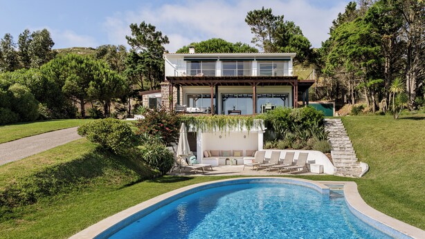 A modern house with a swimming pool, surrounded by lush greenery and a stone pathway leading to a patio area. - SeaView Oasis: 4BR, Pool, Tennis by Host For Us (Alcabideche)