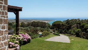A stone building with a pergola, a grassy lawn, and a view of the sea. - SeaView Oasis: 4BR, Pool, Tennis by Host For Us (Alcabideche)