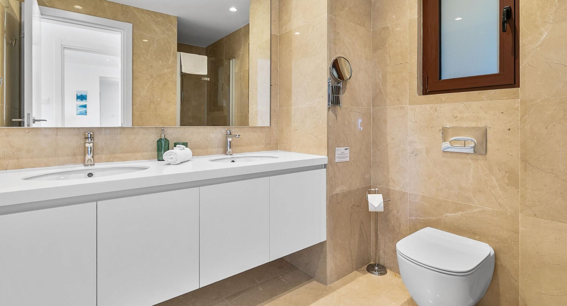 Un bagno moderno con due lavabi, una doccia e un WC.