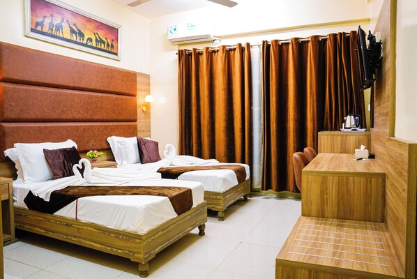 A hotel room with two beds, a wooden headboard, a small table with a kettle, and a large window with curtains. - COMFORT HOTEL (Djibouti)