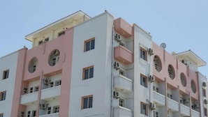 Een meerhoog gebouw met balkons en airconditioners.