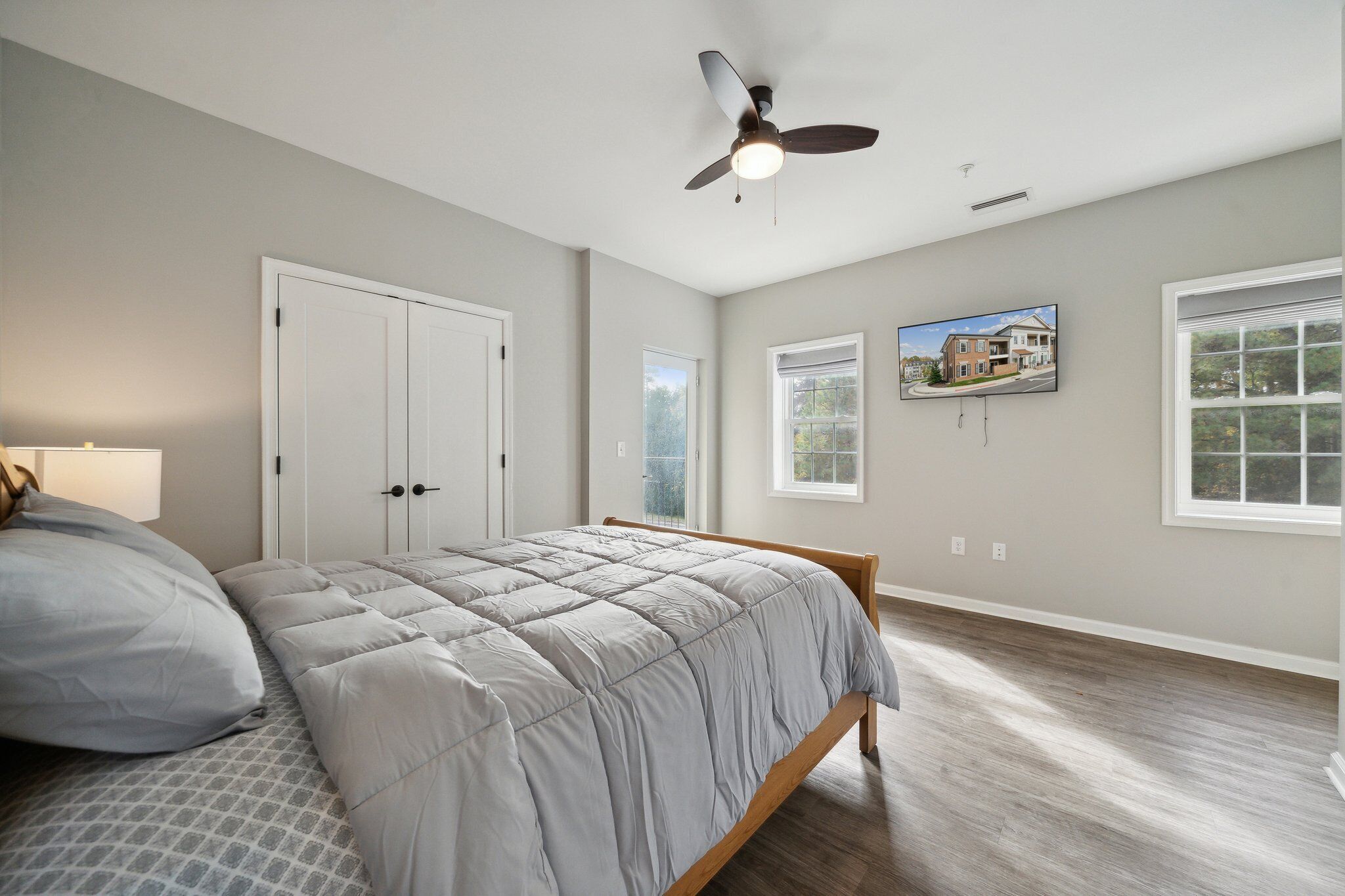 A bedroom with a bed, a ceiling fan, and a window.