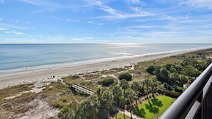 A coastal view from a balcony overlooking a beach with a clear sky. - Welcome to Captain's Bridge with two Ocean Front Primary Suites (Myrtle Beach)