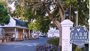 A sign for The Farm Village with a list of amenities including a hotel, shops, and a café.