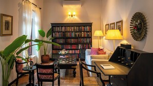 Una sala de estar acogedora con una estantería, una mesa de centro, un sofá y una lámpara.