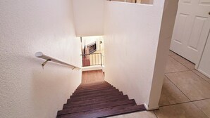 A staircase leading to a landing with a view of a kitchen area. - Cozy 2-bedroom townhome in charming Tucson with AC, WiFi. Located NW of Tucson . (Tucson)