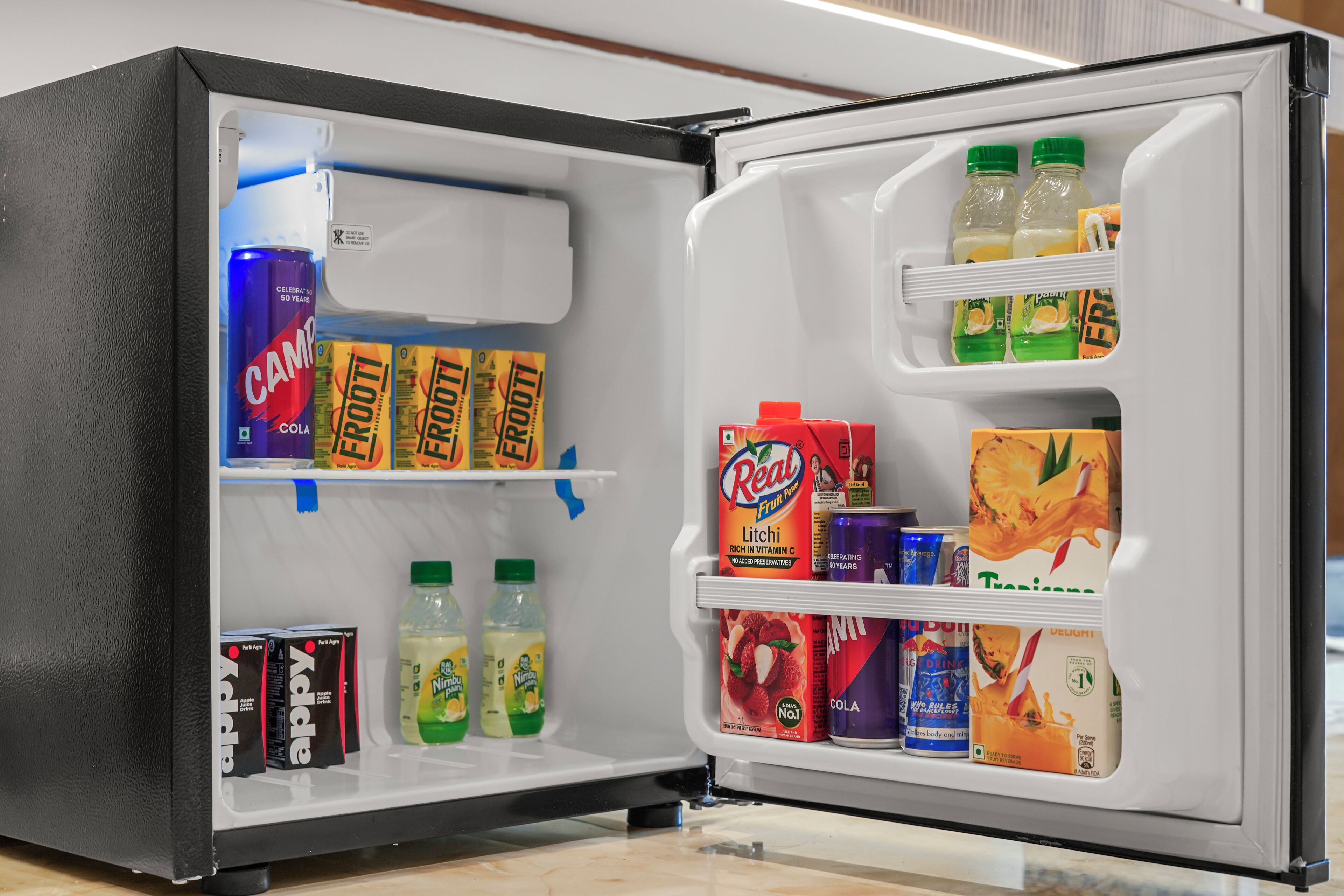 Ein offener Kühlschrank mit verschiedenen Getränken und Snacks.