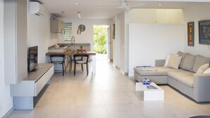 Ein moderner Wohnraum mit Küche, Essbereich und einer Sitzecke mit Sofa und Couchtisch.