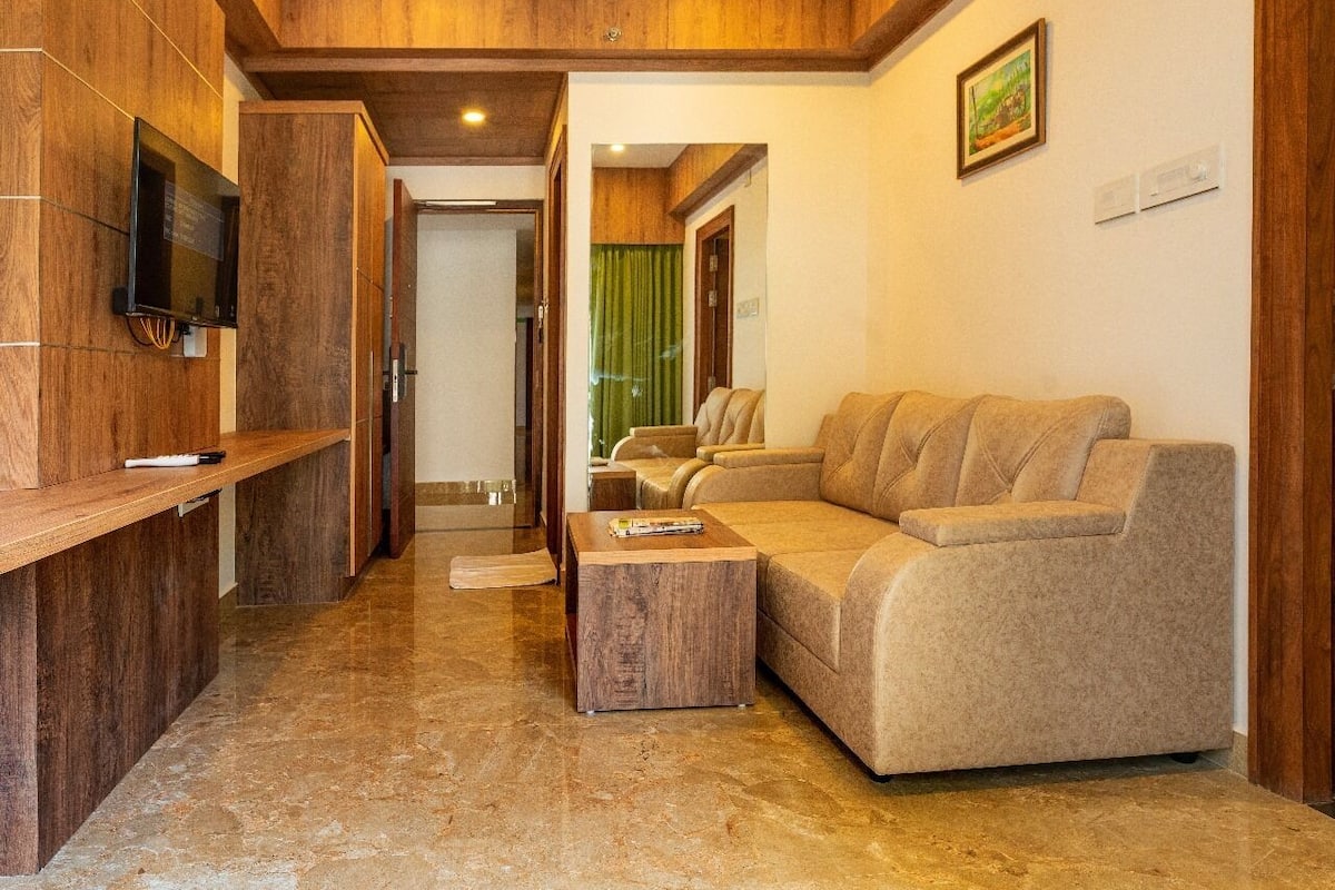 A modern living room with a sofa, a coffee table, and a TV mounted on a wooden wall.