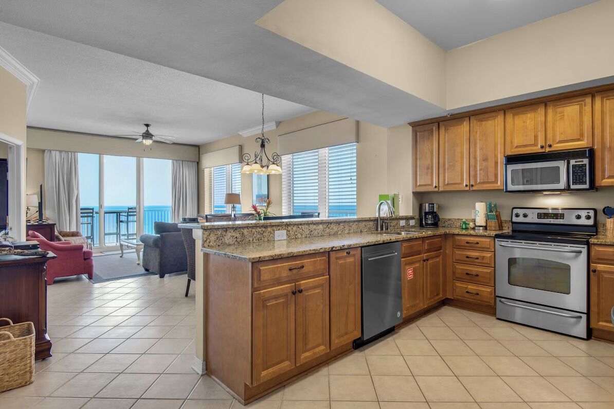 A modern kitchen with wooden cabinets, stainless steel appliances, and a large island.