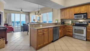A modern kitchen with wooden cabinets, stainless steel appliances, and a large island. - Inn At Summerwind 1405 (Navarre)