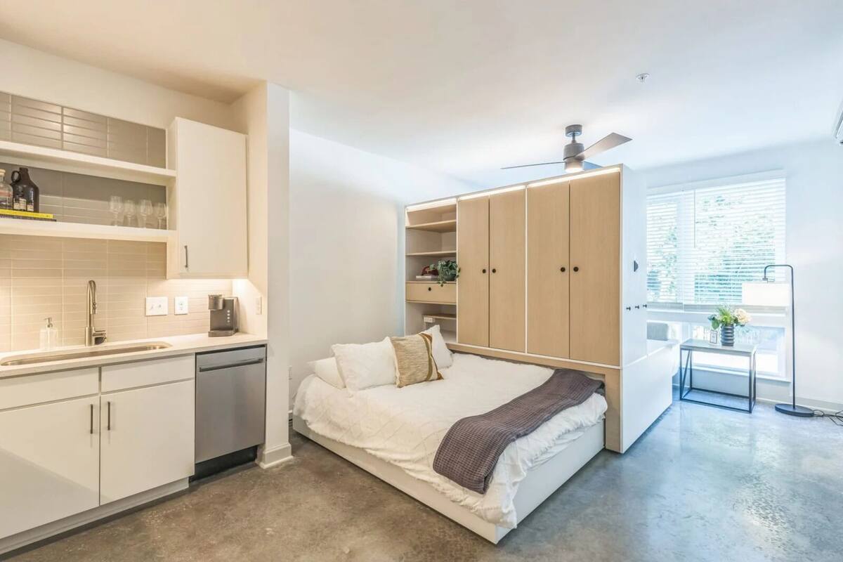 Un dormitorio moderno con cama, mesita de noche y armario.