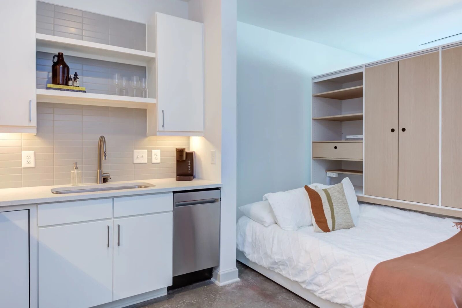 Un dormitorio moderno con cama, mesita de noche y armario empotrado.