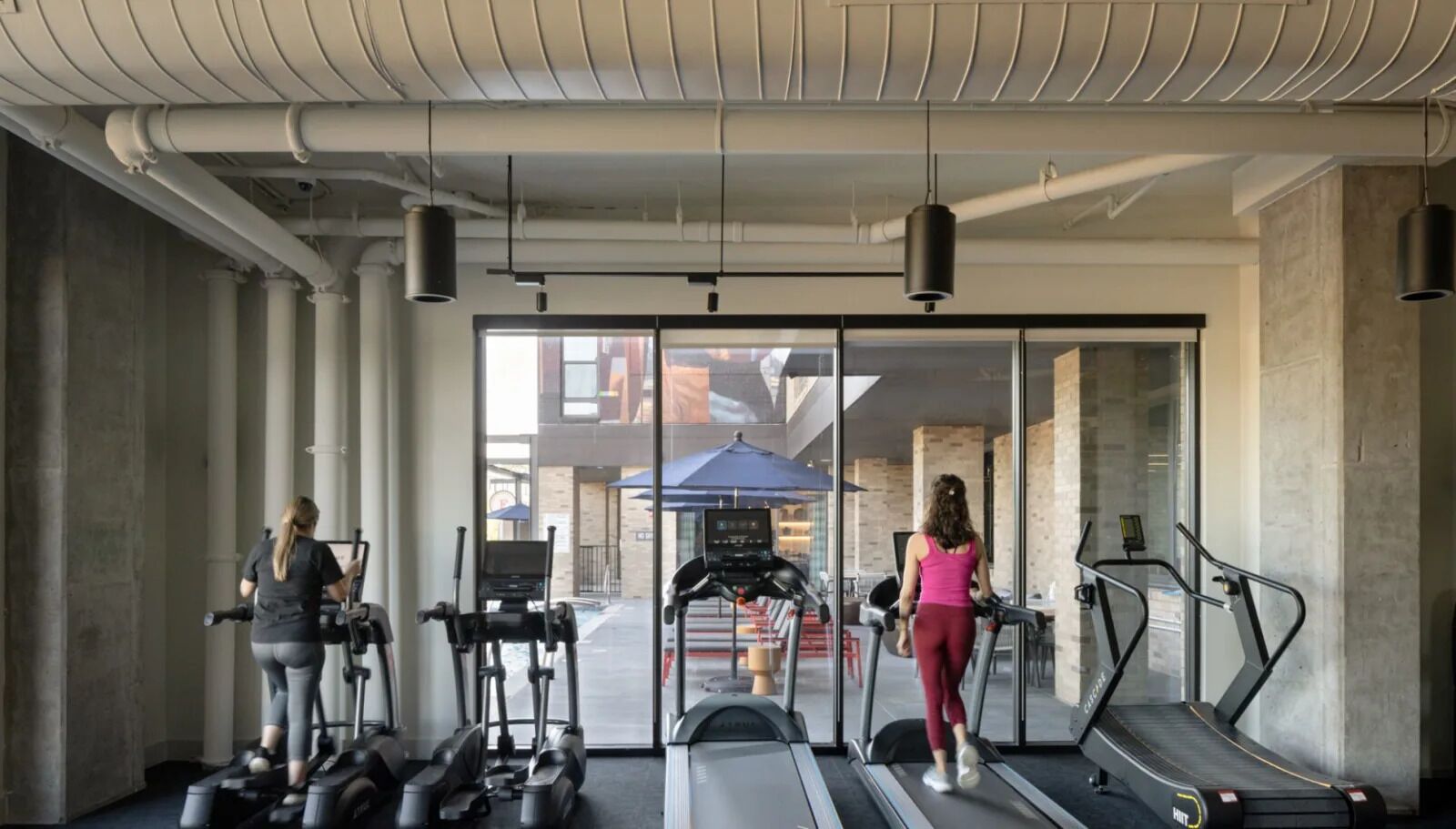 A gym with treadmills, elliptical machines, and weights.