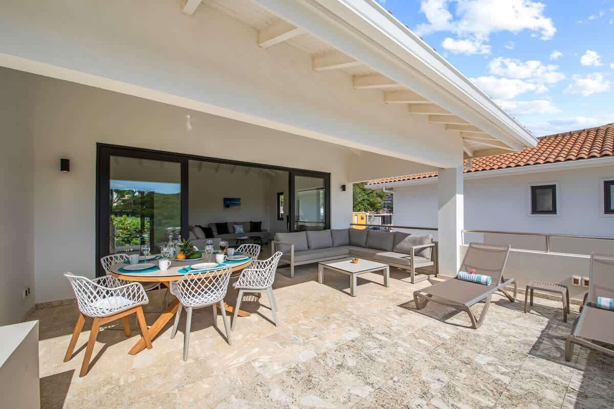Eine Terrassensitzgruppe mit Esstisch, Stühlen, einer Couch und Liegestühlen.