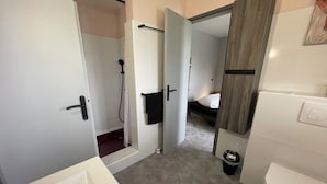Un bany modern amb banyera, vàter i zona de dutxa.