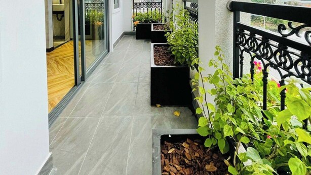 A balcony with a wooden ceiling, tiled floor, and potted plants. - River View Hotel (Ho Chi Minh City)