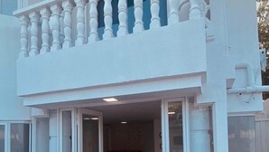 A two-story building with a white exterior, a balcony with balusters, and a welcome mat at the entrance. - Hotel Boutique DL  (Cartagena)