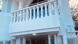 A two-story building with a balcony, large windows, and a welcome mat at the entrance. - Hotel Boutique DL  (Cartagena)