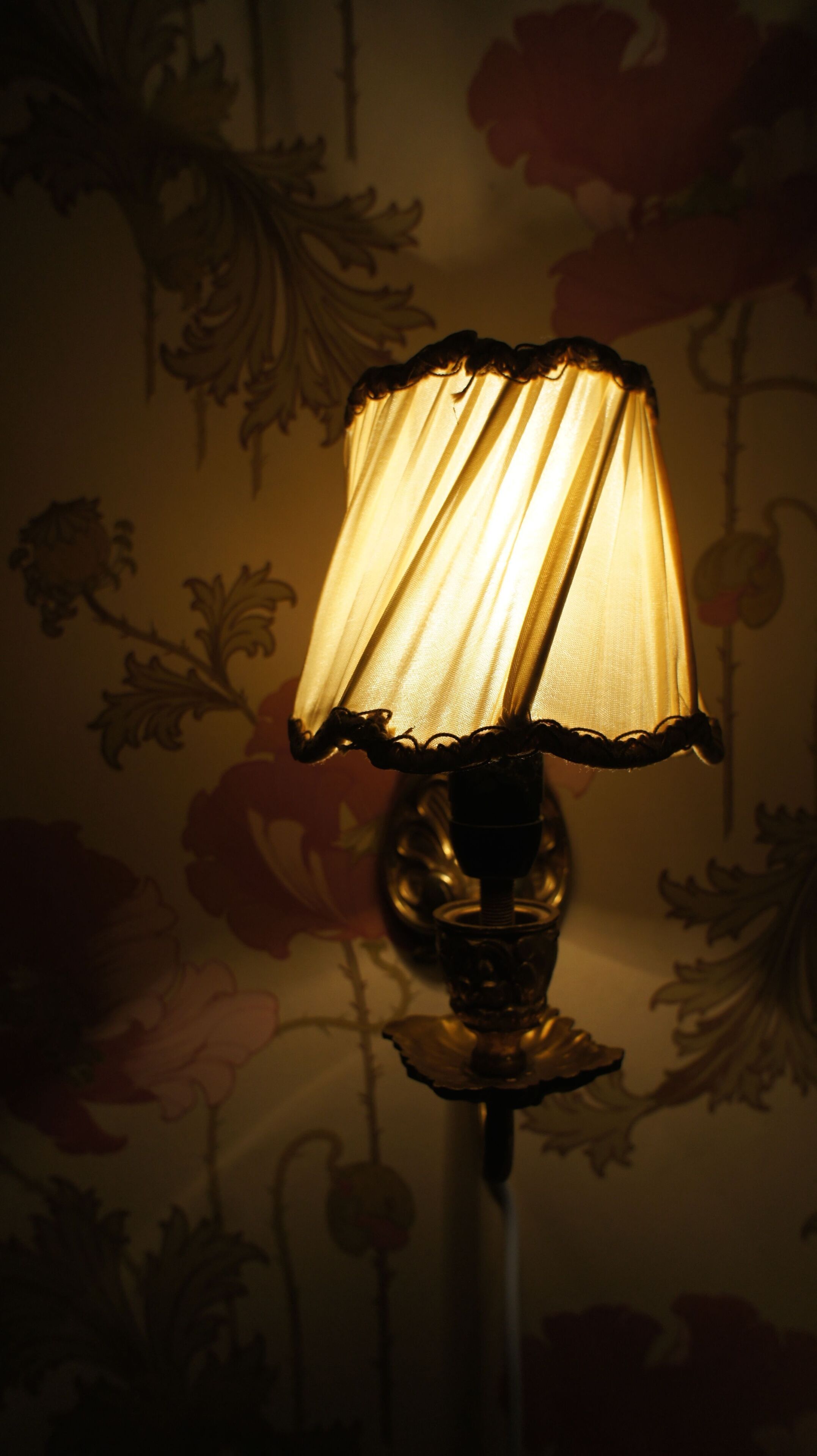 A lamp with a decorative base and a fabric shade.