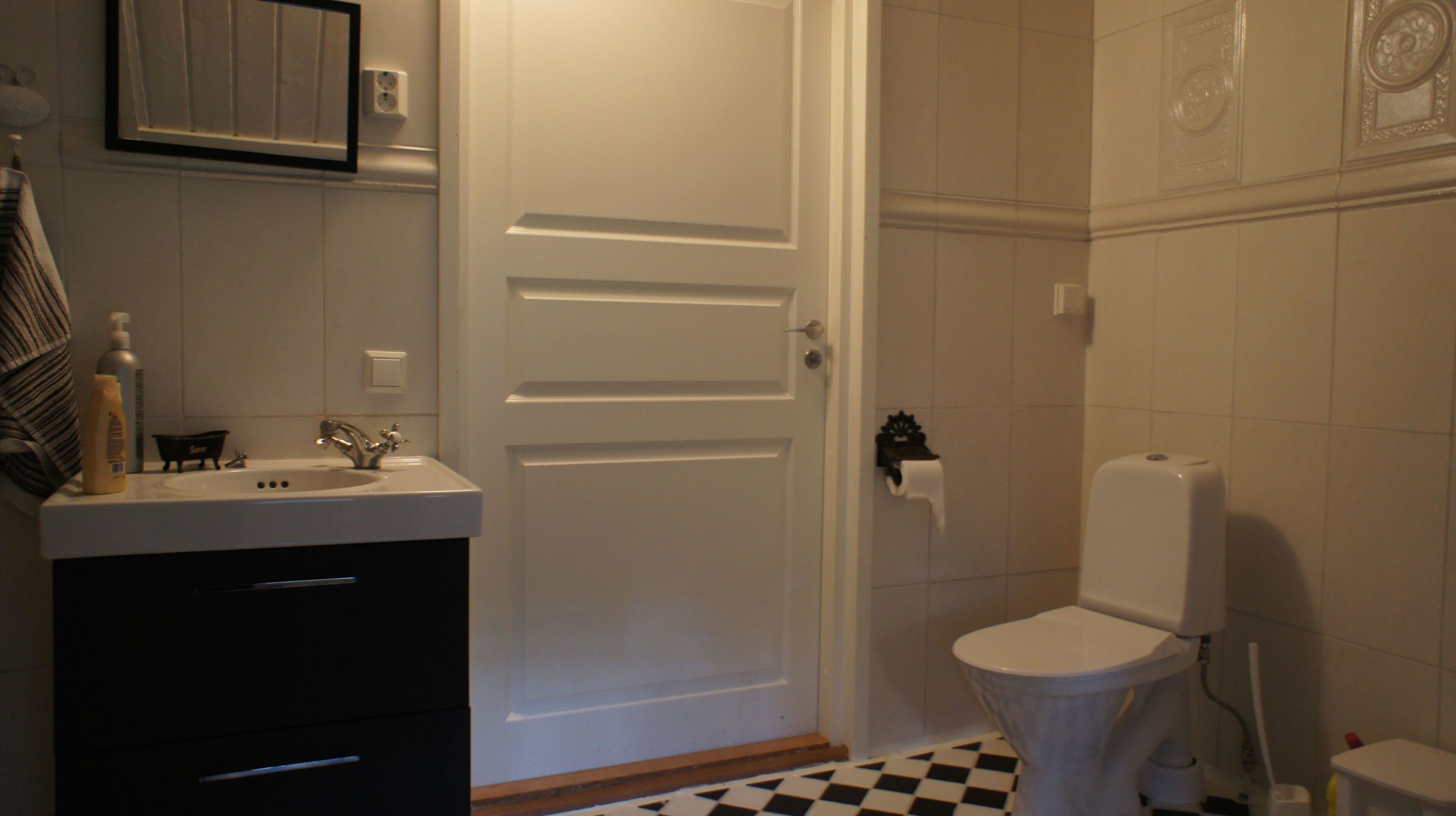 A bathroom with a sink, mirror, and toilet.