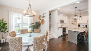 A modern kitchen with white cabinets, stainless steel appliances, and a central island with a sink.