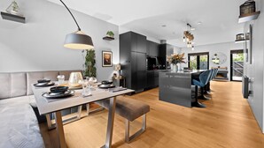 Una cocina moderna con armarios oscuros, una isla central e iluminación colgante.