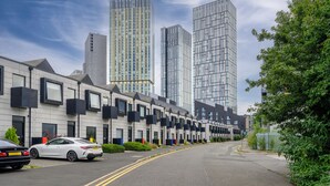 Una hilera de casas adosadas modernas con una calle delante.