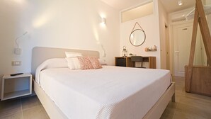 A bedroom with a large bed, bedside tables, a desk, a mirror, and a wardrobe. - B&B CASA GIOVANNA (Isola del Giglio)