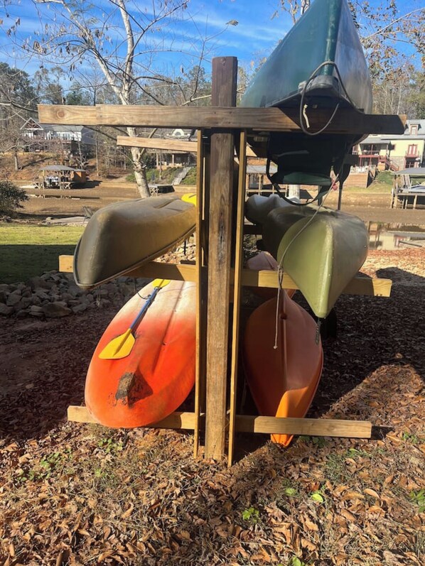 A wooden structure with kayaks and a canoe.