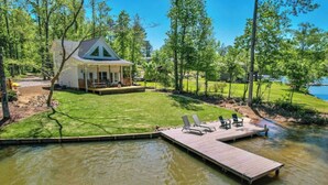 A lakeside cabin with a dock and lounge chairs. - Waverly Creek Retreat-kayaks/fire pit/pet friendly (Jackson's Gap)